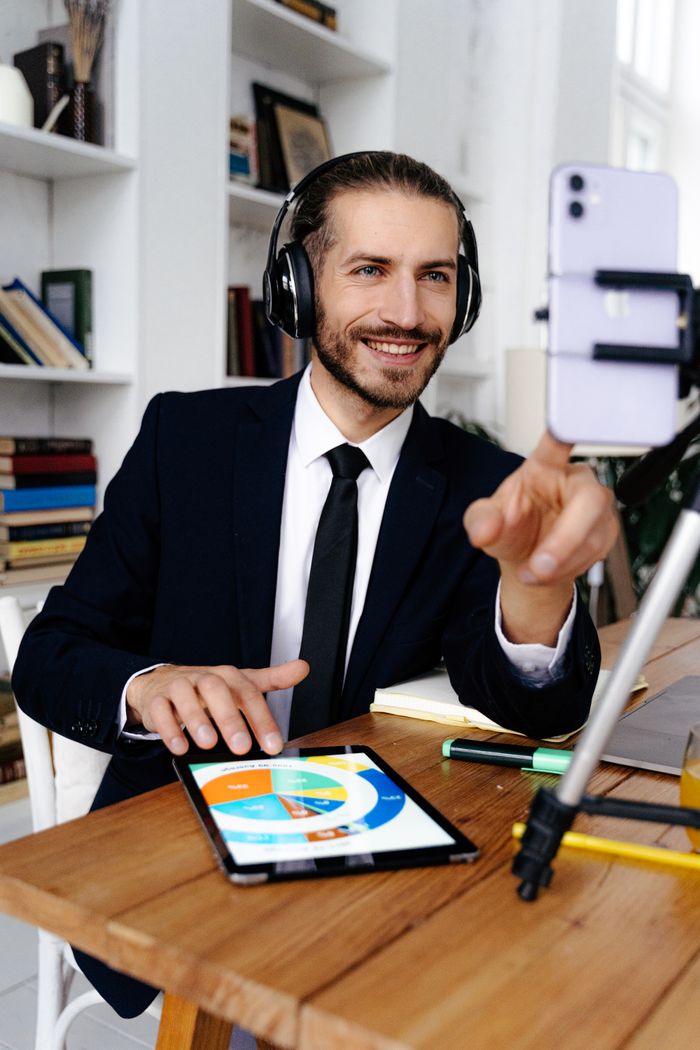 services-img Smiling businessman in headphones using tablet for video call at office desk.